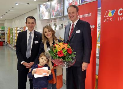 Die dm-Kundin Annika Schwoll (2. von rechts) aus Düsseldorf hat das zwanzigmillionste CEWE FOTOBUCH in Auftrag gegeben und freut sich nun auf eine Flugreise für zwei Personen mit der CEWE AIR aus der TUIfly-Flotte