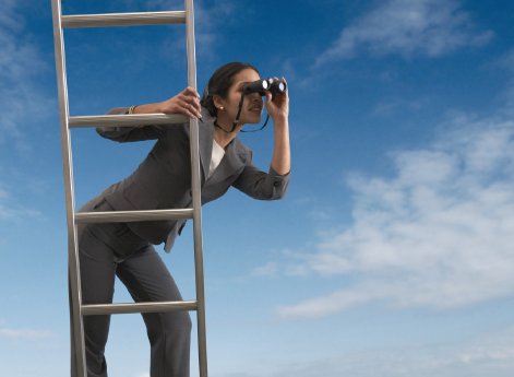 Businesswoman standing on a ladder.JPG
