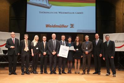 Auszeichnung und Ansporn zugleich: Ulrich Halbey (5.v.l.), Werkleiter in Thüringen, Bettina Geißhirt (7.v.l), zuständig für das Weidmüller Produktionssystem am Standort, und Stephan Köhler (6.v.l), Leiter Qualitätsmanagement vor Ort, nahmen stellvertretend die Ehrung mit dem 2. Platz des Ludwig-Erhard-Preises entgegen