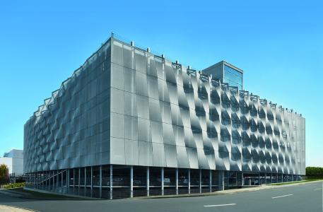 Wie ein schimmernder Kokon legt sich das FACID-Gewebe um den schlichten Kubus des Schüco Parkhauses, Bildnachweis: SCHLATTMEIER ARCHITEKTEN Fassadenkonzept in Kooperation mit 3XN, Fotograf: Christian Eblenkamp