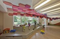 Fantasievoll: In der Form eines Drachens, der durch den Raum fliegt, sind die bunten Melapor-Akustikplatten von Caparol angebracht. Die extra angefertigen Sechsecke stellen die Schuppen am Drachenkörper dar, Foto: Caparol/Duckek, partnerundpartner-architekten