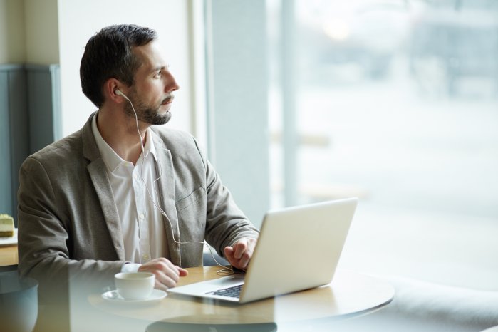 Mann_Kaffee_Laptop_Kopfhörer_Mobil Arbeitend.jpg