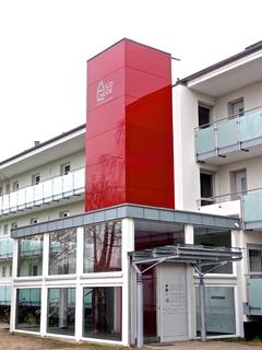 Bei den Häuserzeilen mit Laubengängen bot sich der Anbau von Aufzugstürmen auf dem Weg zu mehr Barrierefreiheit an. Hier wurde der Turm mit Airtec Glass verschönert, Foto: Caparol Farben Lacke Bautenschutz/Axel Schmidt-Adlung