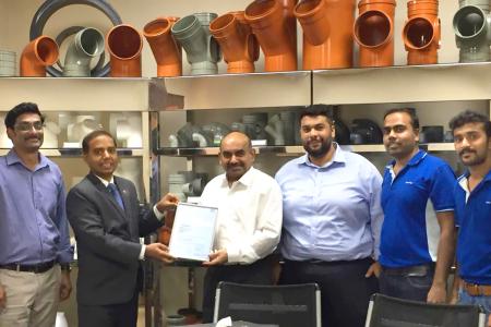 Khaisar Syed (links) überreicht der Firma Bahrain Pipes BSC die Urkunde für 10-jährige Zusammenarbeit mit dem SKZ