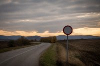 Landstraße mit Tempolimit-Schild in der Abenddämmerung