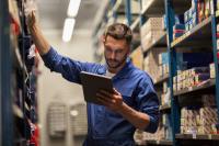 Lagerarbeiter beim Datencheck auf mobilem Endgerät