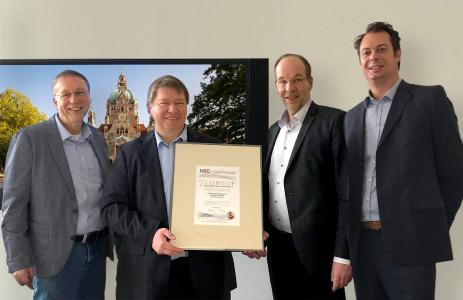Bereichsleiter SAM, Oliver Schäpe (ganz rechts), überreicht das U-S-C SAM Zertifikat an die Verantwortlichen der Landeshauptstadt Hannover (von links nach rechts: Herr Kropp, Herr Rackow und Bereichsleiter Herr Vogel) als Compliance Nachweis für Microsoft und Wirtschaftsprüfer.