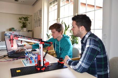 Marius Warzecha (Dualer Student Elektrotechnik) mit Lars Dittmar bei der Programmierung eines Industrie-Anlagen Modells