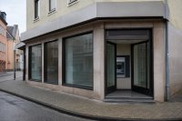 Geschlossene Bankfiliale in einer Ortsmitte - Eine ehemalige Bankfiliale in einer kleinen Ortsmitte, die Schaufenster sind leer geräumt, davor steht ein einzelner Geldautomat in einem Vorraum. Symbolbild zum Rückgang des Zweigstellennetzes in Deutschland