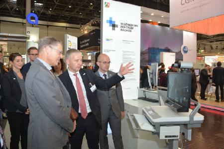 Univ.-Prof. Dr. med. Gernot Marx, FRCA, Direktor der Klinik für Operative Intensivmedizin und Intermediate Care an der Uniklinik RWTH Aachen und Mitglied des ZTG-Forums Telemedizin (Mitte), und Dr. med. Robert Deisz, Oberarzt an der Klinik für Operative Intensivmedizin und Intermediate Care an der Uniklinik RWTH Aachen (rechts) demonstrieren NRW-Staatssekretär Dr. Edmund Heller (links) an einer Live-Demo, wie das Projekt TELnet@NRW die Videokommunikation zwischen Arzt und Patient erleichtert. (Foto: ZTG)