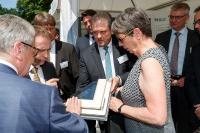 Wallfried Herzog, Sprecher der Geschäftsleitung der Schüco Polymer Technologies KG erläutert Bundespräsident Joachim Gauck und Bundesbauministerin Barbara Hendricks die Beschichtungstechnologie Schüco AutomotiveFinish