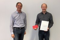 SKZ-Institutsdirektor Prof. Dr.-Ing. Martin Bastian (links) übergibt die Jubiläums-Urkunde an SKZ-Geschäftsführer Dr. Thomas Hochrein. (Foto: SKZ)