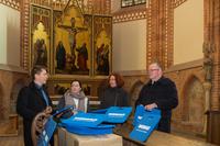 WEMAG-Mitarbeiterin Katja Juhnke (2.v.l.) überreicht Pastor Christian Hasenpusch (li.), Diakonin Sonnhild von Rechenberg und Hans Hopkes, Leiter des Diakoniewerkes Kloster Dobbertin, 200 Sitzkissen für die Klosterkirche (Foto: WEMAG/Rudolph-Kramer)