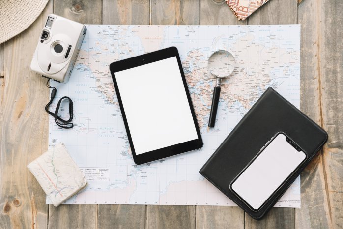 top-view-digital-tablet-cell-phone-magnifying-glass-diary-map-against-wooden-background.jpg