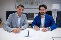 Patrick Fruth (left), CEO of the Mobility Division at TÜV SÜD, and Rafael Osmanov, founder of Helix Partners, sign the purchase agreement