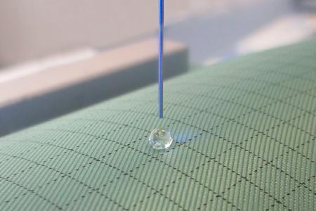 Round drops with correspondingly large contact angles form on the coated cleanroom textiles