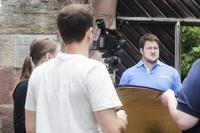 Der Olympiasieger im Gewichtheben Matthias Steiner, der u. a. als Markenbotschafter für AFRISO tätig ist, war kürzlich in einem Gebäude der Fürstlich Leiningenschen Verwaltung in Amorbach, um sich über die Auswirkungen des hydraulischen Abgleichs zu informieren. Der Tag mit Matthias Steiner wurde gefilmt; der Film wird im August auf der AFRISO Homepage und dem YouTube Kanal www.youtube.com/afrisoDE zu sehen sein. (Foto: AFRISO)