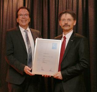 Kai-Uwe Reiß von pro-K überreicht Thomas Sauer, Leiter Entwicklungsbereich B und Elektronik bei ebm-papst, die Urkunde