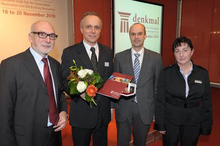 Die Goldmedaille stiftete die Leipziger Messe GmbH. Das Foto zeigt die Preisverleihung durch den Geschäftsführer der Leipziger Messe Markus Geisenberger (zweiter von rechts) an Dr. Christian Brandes von der Caparol-Baudenkmalpflege (zweiter von links). Rechts im Bild Dr. Deliane Träber, die für die "denkmal" verantwortlich zeichnet