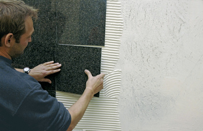 Wall laying of natural stone tiles with PCI Carralight. Photo: PCI