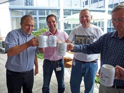 Von links nach rechts: Prof. Lothar Frey (Leiter Fraunhofer IISB und Lehrstuhl für Elektronische Bauelemente), Jörg Diebel (Geschäftsführer NanoWorld Services GmbH), Peter Besmens (Produktmanager) und Hans-Jürgen Lüdge (Produktionsleiter) stoßen auf dem gemeinsamen Sommerfest am 19. Juli 2012 auf die zehnjährige Kooperation zwischen Fraunhofer IISB und der NanoWorld Services GmbH an. Bild: Fraunhofer IISB