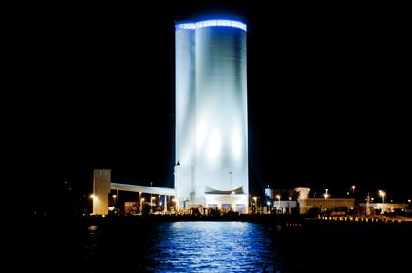 Skylinie des Mehrkammersilos bei Nacht mit Schiffsentladestation und Becherwerksturm
