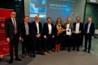 Sparkassen Vorstandsvorsitzender Arendt Gruben, rechts im Bild, und sein Stellvertreter Florian Klausmann, links, überreichen den Vertretern der Jauch Quartz GmbH den Sonderpreis des Innovationspreises für die amagnetische Lithium Polymer Batterie
