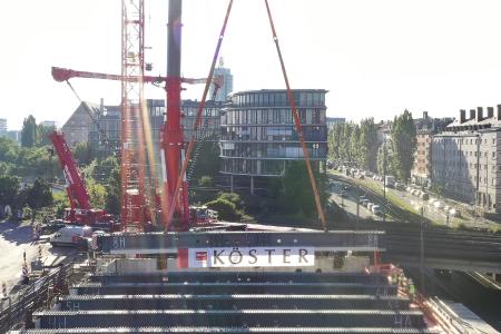 Kernaufgabe des Teleskop-Raupenkrans war das Heben, Transportieren und millimetergenaue Setzen der bis zu 74 Tonnen schweren Träger bei einer Ausladung von bis zu 50 Meter für die Ballsaal-Decke des Mucon München.
Bildquelle: Köster GmbH