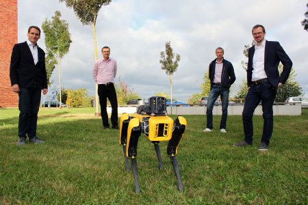 Das SHELLS-Projektteam begrüßt „Spot“, einen autonomen Laufroboter, der hinsichtlich seiner Optik und Bewegungsabläufe einem Hund nachempfunden ist, an der Fakultät für Technik der Hochschule Pforzheim: Professor Mike Barth, Professor Norbert Schmitz, Professor Hanno Weber und Michael Jilg (von links). (Foto: Sophia Zundel / Hochschule Pforzheim)