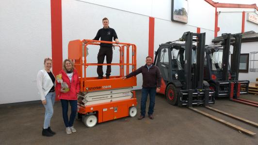 Die Übergabe der Snorkel S3219E. Von links: Tochter Manuela Pflanz, Frau Helga Pflanz, mit Sohn David Pflanz von der Firma Karl Pflanz Gabelstapler-Service GmbH und Jürgen Müller, Vertriebsmitarbeiter, Ahern Deutschland GmbH für Süd-Ost Deutschland und Österreich