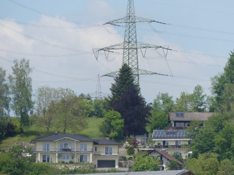 Strommast Stromleitung vor Dorf Häusern@SOLAR-professionell_mgrogus.JPG