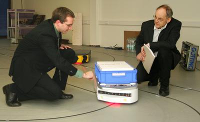 Dr. Sebastian Behling (links) und Hans-Heinrich Götting mit „KATE“. Die „kleine automatische Transport-Einheit“ wurde von der Lehrter Firma Götting entwickelt. Im Forschungsprojekt „FTF out of the box“ soll sie Sehen, Hören und Denken lernen. (Foto: Susann Reichert / IPH)