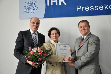 Rolf Lay (links), Vizepräsident der IHK Magdeburg und Wolfgang März, Hauptgeschäftsführer der IHK Magdeburg überreichen Ludmilla Seel die offizielle Urkunde zum Bescheid im Rahmen einer Pressekonferenz am 21. Februar 2013