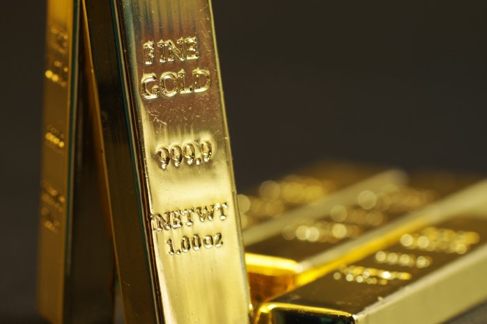 Close up shot of stacked 999.9 pure gold bar ingot on a black background, represented the busine.jpg