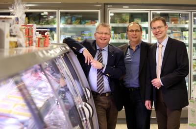 Eiskalt gespart: Jens Segebrecht (l.) präsentiert Udo Sahling (m.) und Harald Halfpaap (r.) die effizienten Kühlregale in seinem modernisierten Schlemmermarkt