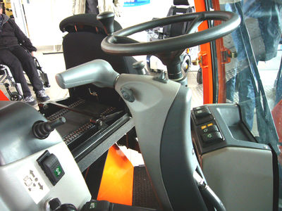 Als weitere Innovation und Highlight findet der Fahrer an seinem Arbeitsplatz einen multifunktionalen Handbedienhebel für die Fahr- und Bremsfunktion. (siehe Erklärung „Zusatzblatt“)