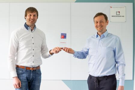 Guido Nippe, Head of IT Consulting und Matthias Besenfelder, Vorstand (v. l. n.) mit der Great Place to Work® Trophäe