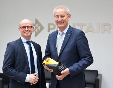 Hans-Peter Werner (rechts) überreicht symbolisch eine U3K Tauchpumpe, eines der Kernprodukte aus dem Hause Jung Pumpen, an seinen Nachfolger Reiner Belscheid, Foto: Jung Pumpen GmbH