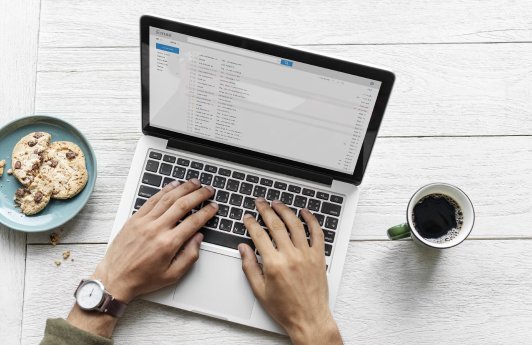 vogelperspektive-eines-mannes-der-computerlaptop-auf-holztisch-verwendet.jpg