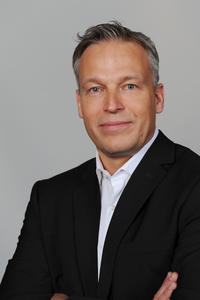 Holger Cremer, Leiter Research & Development Mechatronik für Europa bei der Dematic GmbH freut sich über die niedrigen Energiekosten des neuen Palettiersystems. (Foto: Dematic GmbH)