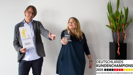 Jörg Popow (COO) und Stefanie Siebenkäß (Head of Customer Service) präsentieren stolz den Pokal „Deutschlands Kundenchampion 2020“.