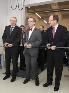 Eröffnungszeremonie: Gemeinsam durchschnitten Prof. Dr. Peter Pleus, Be-reichsvorstand Automotive (rechts), Dr. Arbogast Grunau (Mitte) und Dr. Alfred Pe-cher im Rahmen einer kleinen Feierstunde das grüne Band am Eingang zu den neuen Räumlichkeiten