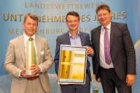 WEMAG-Vorstand Caspar Baumgart und WEMAG-Nachhaltigkeitsmanager Julian Höhn nehmen den Preis von Mecklenburg-Vorpommerns Wirtschaftsminister Reinhard Meyer in Empfang (v.l.). Foto: WEMAG/Stephan Rudolph-Kramer