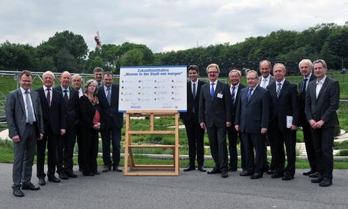 Gruppenfoto, auf dem die Vertreter der Städte gemeinsam mit Dr. Jochen Stemplewski, dem Vorstandsvorsitzenden der Emschergenossenschaft, im Bottroper BernePark die symbolische Unterschriftensammlung präsentieren (Foto: TIM FOLTIN/Emschergenossenschaft)