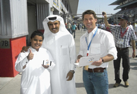 Bildunterschrift: Andre Jurleit (im Bild rechts), Geschäftsführer der GPSoverIP GmbH, in der Boxengasse des „Dubai Autodrome“.