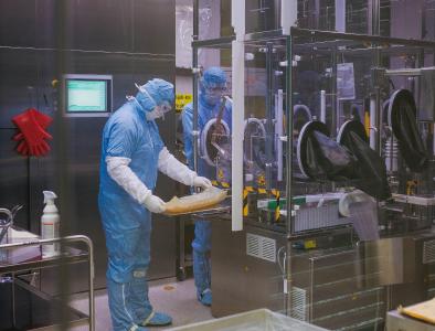 Der Blick in die Impfstoffabfüllung ist bei laufender Produktion nur hinter der Glasscheibe möglich. Die Mitarbeiter Björn Dalichau und Andreas Müller bereiten die Linie für die Abfüllung des SARS-CoV-2-Impfstoffkandidaten vor