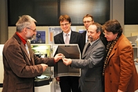 Prof. Dr. Andreas Niegel (links) zeigt eine bearbeitete Probe aus dem Glimmentladungsspektrometer. (vlnr) Ralf Hoppe , Dr. Eberhard Niggemann , Prof. Tilmann Fischer und Dr. A. Heinrike Heil 