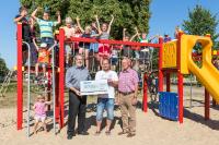 Im Rahmen der Wiedereinweihung des Kinderspielplatzes überreichte WEMAG-Kommunalbetreuer Bernd Halfkath (li.) den symbolischen Spendenscheck im Beisein des Bürgermeisters Jürgen Kühl (re.) an den stellvertretenden Vorsitzenden des Vereins Spielplatz-Freunde e.V. Suckow, Ronny Kleinke / Foto: WEMAG/Stephan Rudolph-Kramer