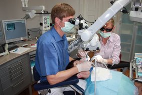 Dipl-Stom Michael Arnold Dresden bei der Behandlung mit dem Dentalmikroskop.jpg