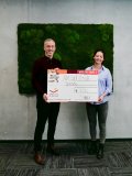 Dr. Tobias Schelter übergibt den Spendenscheck an Alina Niederberger